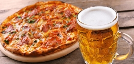 یک لیوان آبجو در کنار پیتزا